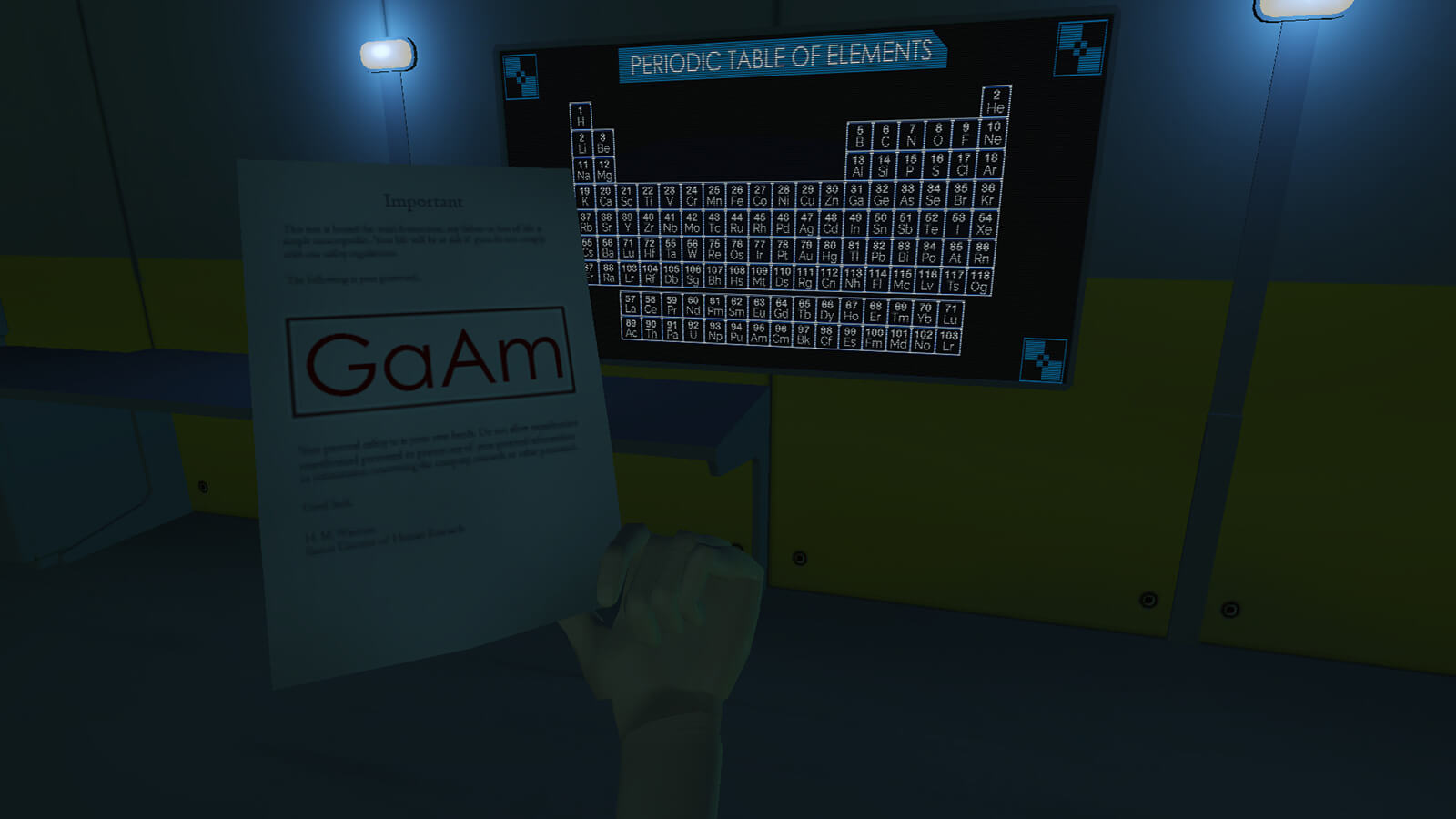 In a dark room, a sheet of paper reading "GaAm" is held up to a black-and-blue Periodic Table of Elements poster on the wall.