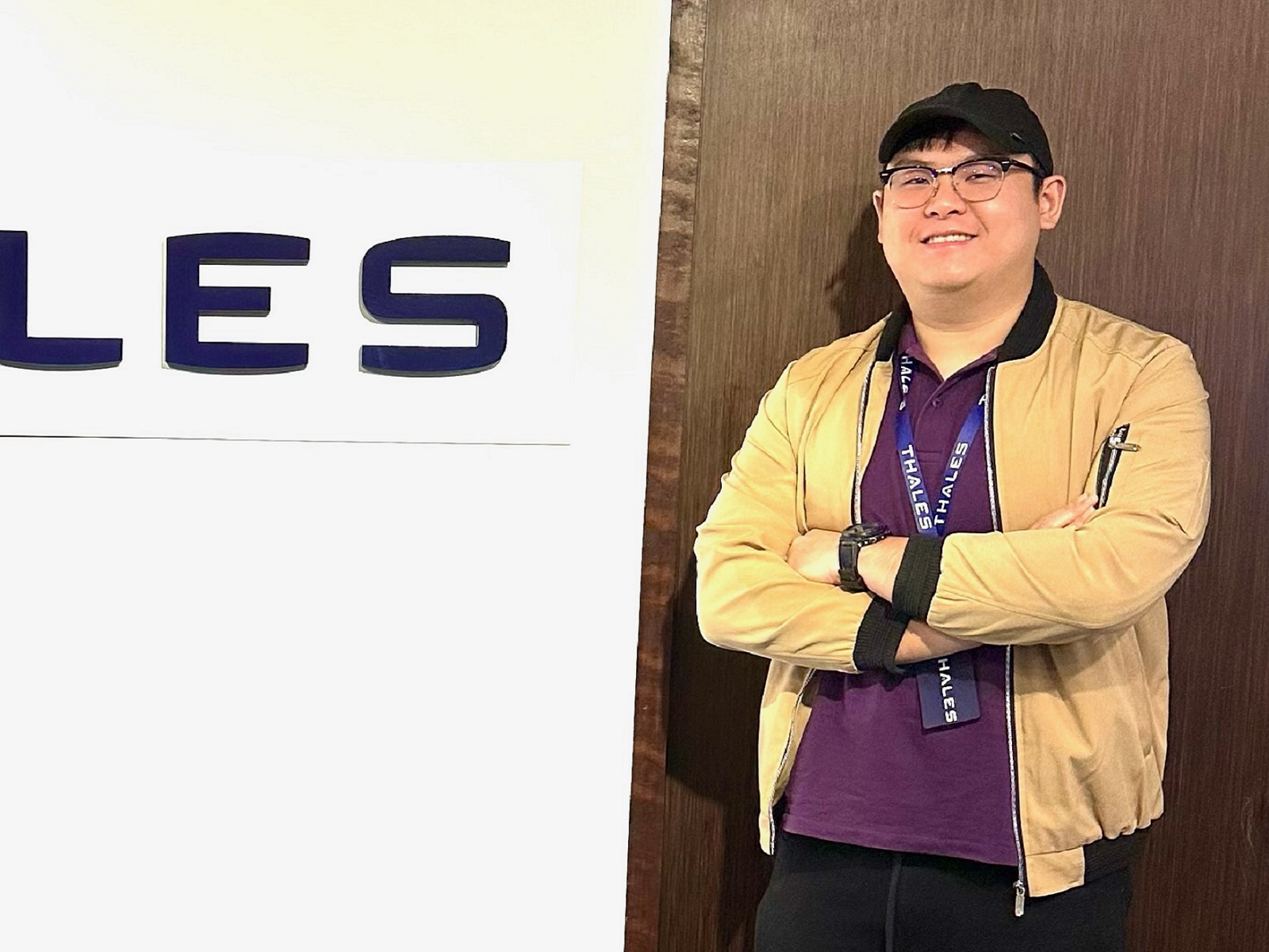 DigiPen graduate Marcus Lee stands in front of the Thales logo