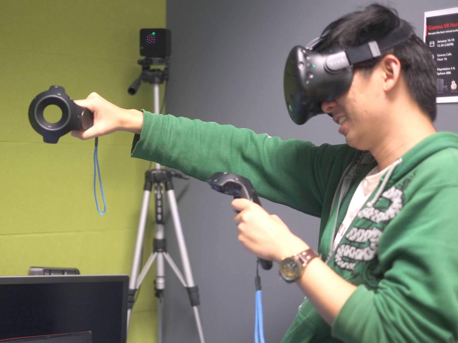 Side view of DigiPen graduate Sim Wei Jin using a VR headset and extending his right arm while using hand-motion controls