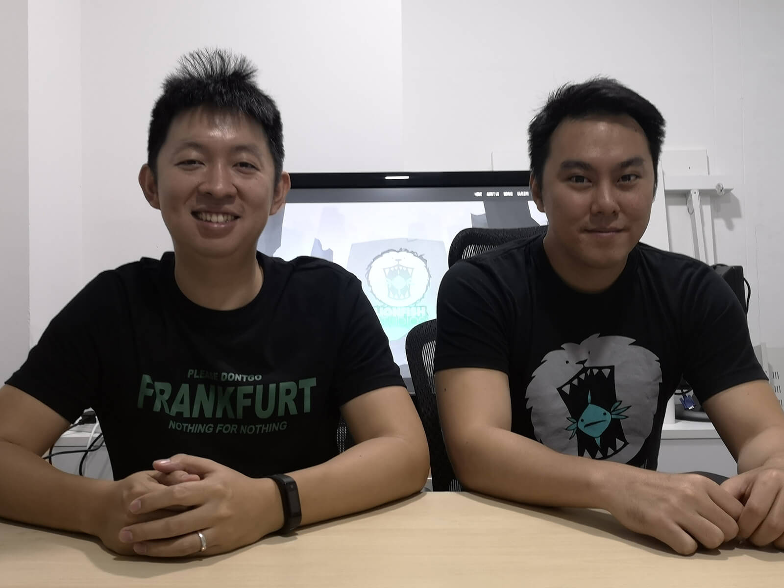 DigiPen (Singapore) alumni Zhang Zi Tian and Koh Shi Xiang sit in the office of Lionfish Studios, which they co-founded