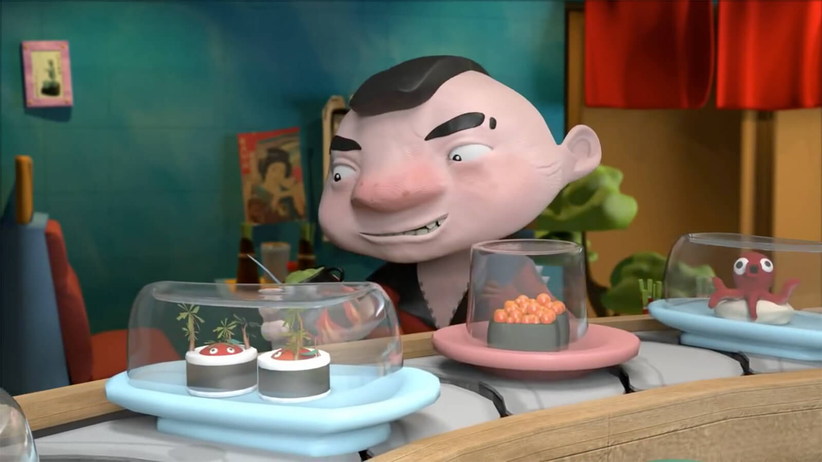 A short man with a mohawk haircut sits behind a sushi conveyor belt with playes of inventive creations under glass.