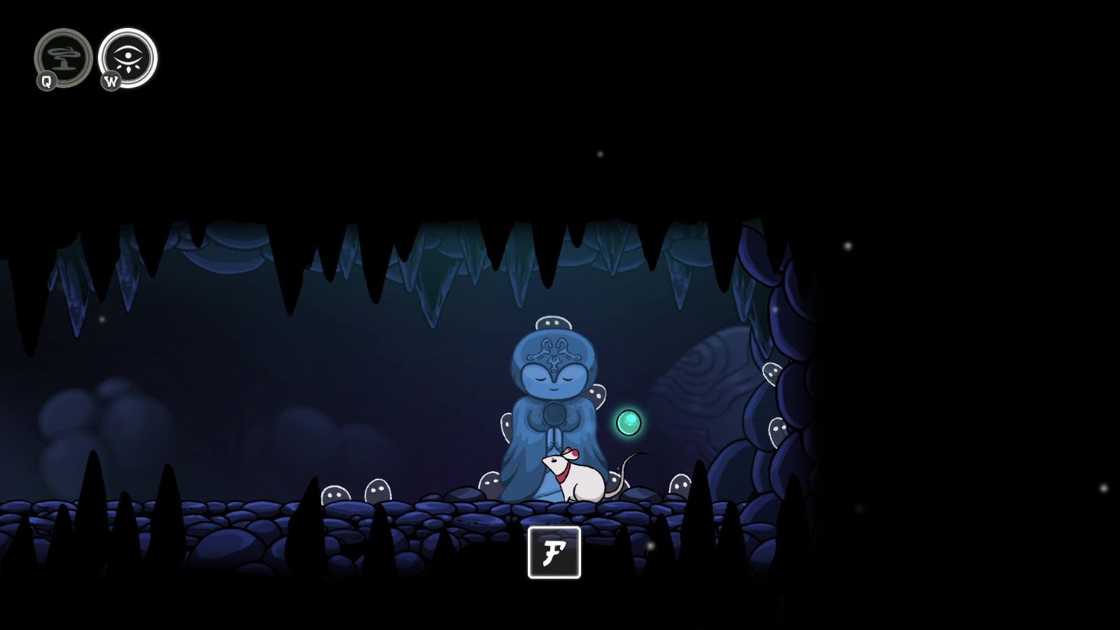 A mouse sits in front of a small statue in a dark cave