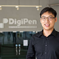 DigiPen (Singapore) alumnus Scott Lim poses in the DigiPen (Singapore) lobby